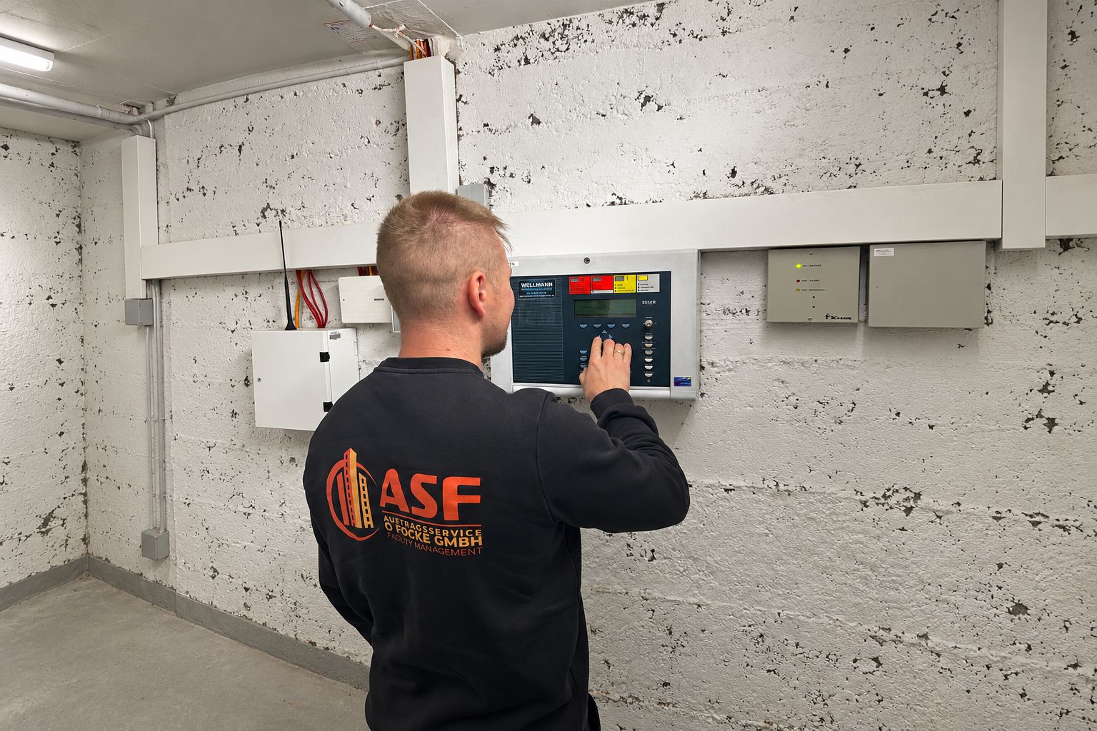 ASF-Mitarbeiter bedient eine Brandmeldezentrale im Keller